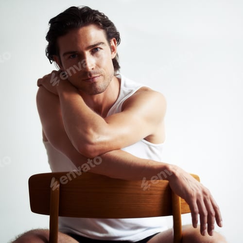 Preview: He has a sensual stare. Portriat of a handsome young man sitting on a chair.