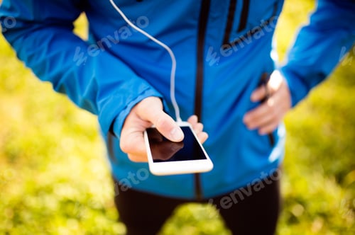 Preview: Unrecognizable runner with smart phone, using fitness app