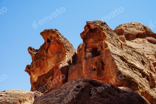 Preview: Low angle shot of rocky desert mountains with blue sky in the background, Jordan