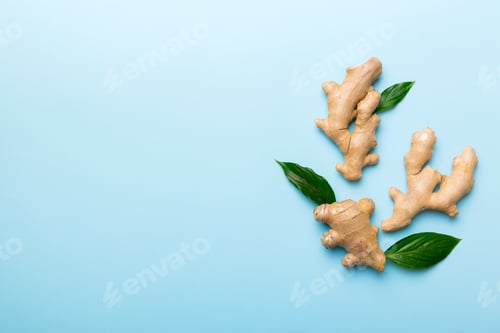 Preview: Finely dry Ginger powder in bowl with green leaves isolated on colored background. top view flat lay