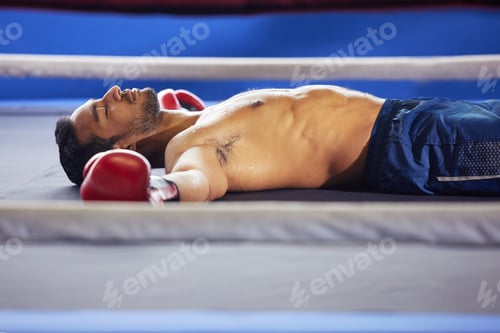 Preview: Cropped shot of a handsome young male boxer lying in the ring with his eyes closed after a fight