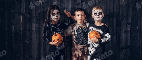 Preview: Three multiracial kids in scary costumes posing with pumpkins in an old house.