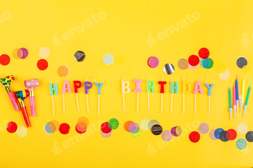 Preview: Happy birthday greeting text maked with candles and decorated with confetti on yellow background