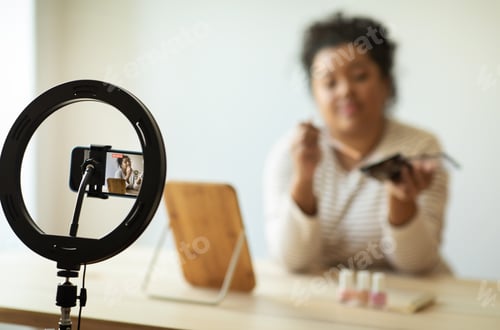 Preview: Smartphone recording hispanic woman holding brand new cosmetics