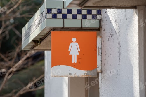 Preview: Close-up shot of ladies' restroom sign on an old metallic banner