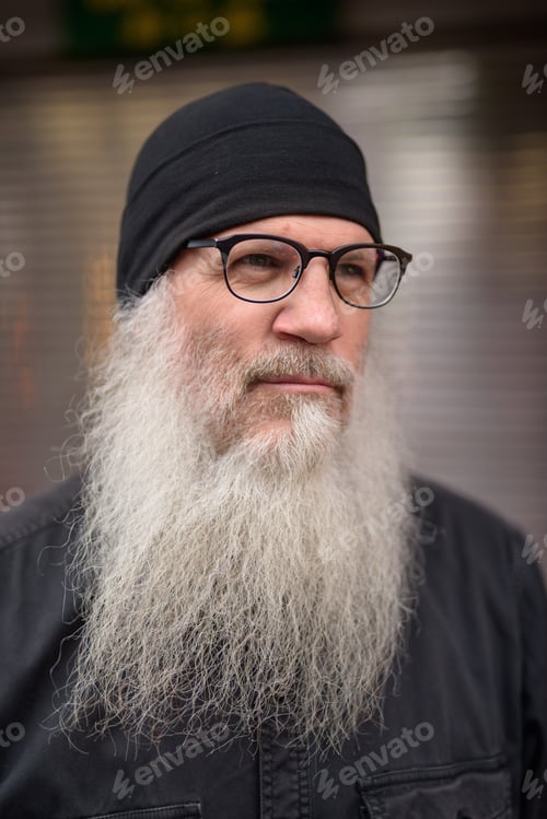 Preview: Face of mature handsome bearded man thinking in the streets outdoors