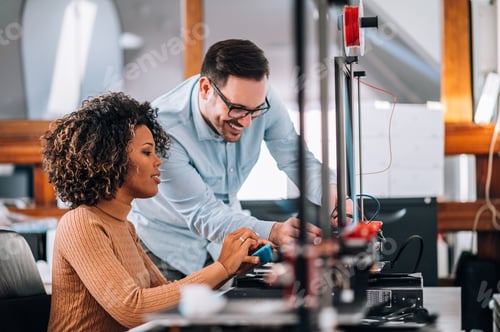 Preview: Engineer showing to a young woman how to use 3D printer.