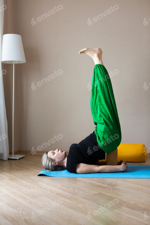 Preview: Middle aged woman doing yoga indoors