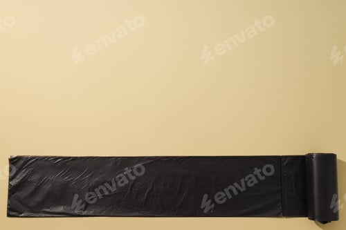 Preview: Roll of black garbage bags on beige background, space for text