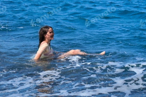 Preview: Laughing teen girl having fun in the sea, playing with sea wave