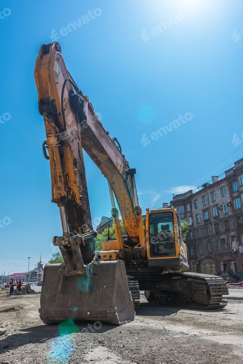 Preview: Excavator and his big bucket during the construction of the road against the backdrop of urban
