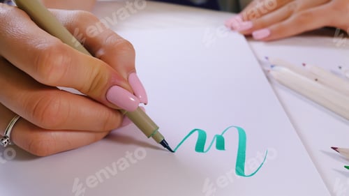 Preview: Calligrapher hands writes word on white paper. Inscribing ornamental decorated letters.