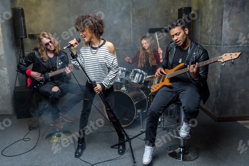Preview: young rock band rehearsing in musical studio, band on stage concept
