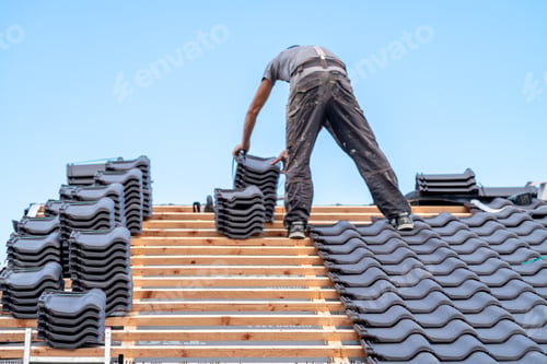 Preview: a craftsman installs a fired ceramic tile on the roof of family house
