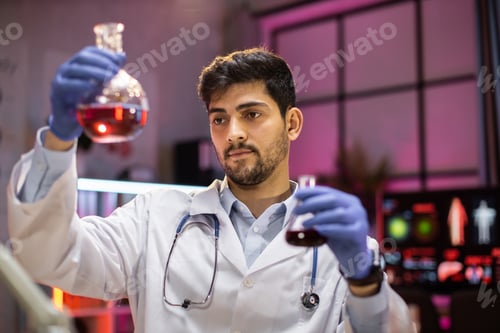 Preview: Indian male scientist working with flask, analysing biochemicals samples.