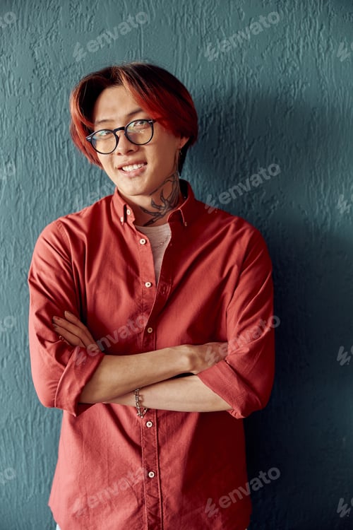 Preview: Happy Asian man posing in studio while looking at camera