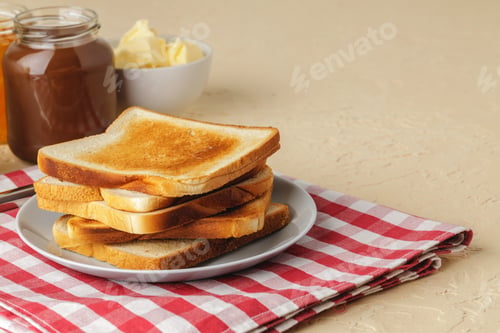 Preview: Slice of fresh bread with butter and jam on table