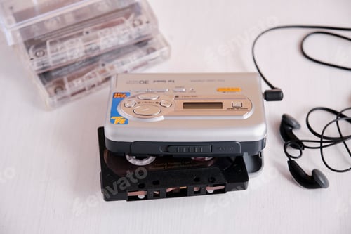 Preview: Portable stereo radio cassette player with headphones, cassettes on the white table.