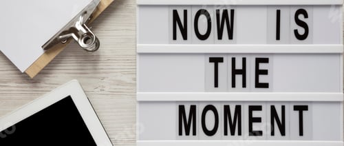 Preview: Top view, lightbox with text 'Now is the moment', tablet with blank screen, clipboard