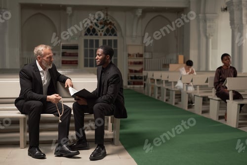 Preview: Black Priest Talking to Senior Man in Church