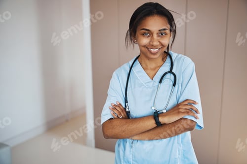 Preview: Charming female doctor with stethoscope standing in clinic