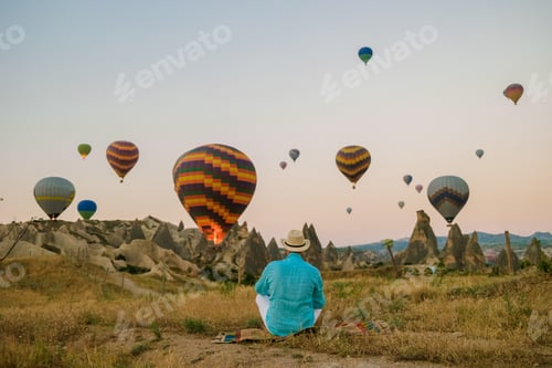 Preview: Young men watching hot air balloon during sunrise in Cappadocia Turkey, Kapadokya Goreme