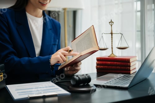 Preview: Woman lawyer reading legal book with gavel on table in office. justice and law ,attorney concept.