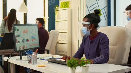 Preview: Black woman working on computer in new normal office