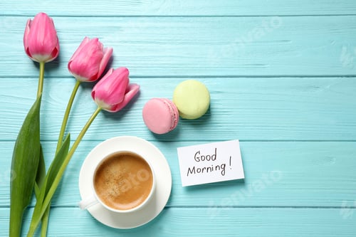 Preview: Flat lay composition with message GOOD MORNING and coffee on light blue wooden table. Space for text