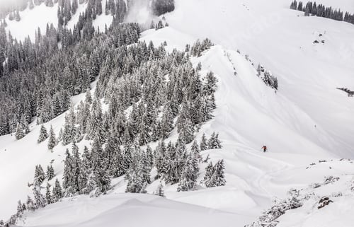 Vorschau: Fernblick auf einen männlichen Skifahrer, der in Kranzegg bergauf geht, Bayern, Deutschland