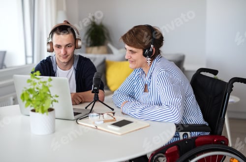 Preview: Disabled people sitting at the table indoors at home, recording podcast at home