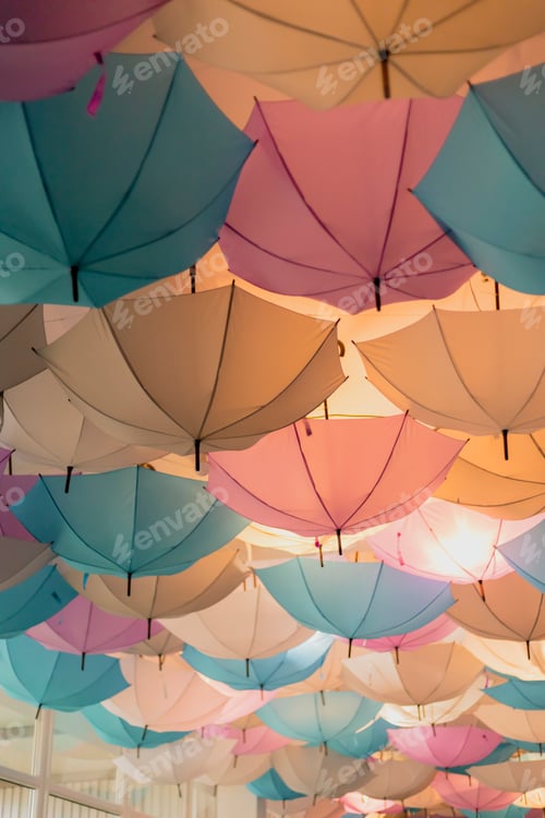 Preview: A vibrant display of umbrellas in shades of pink, blue, and cream adorns the ceiling