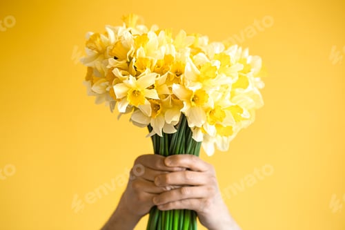 Preview: Background male hands with a bouquet of flowers .