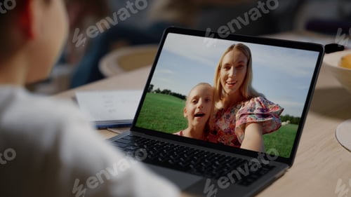 Preview: Boy videocalling mother online at home closeup. Cheerful family talking web cam