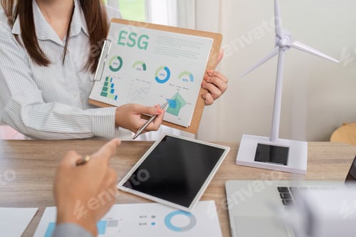Preview: ESG Presentation. Business professionals analyzing data and discussing renewable energy models.