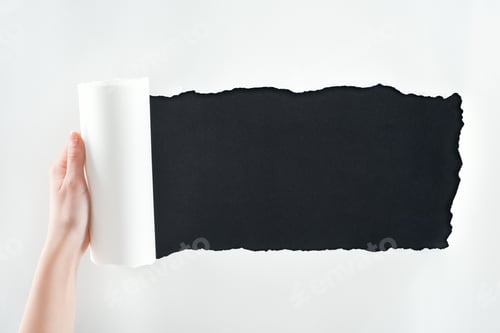 Preview: cropped view of woman holding textured white paper with rolled edge on black background