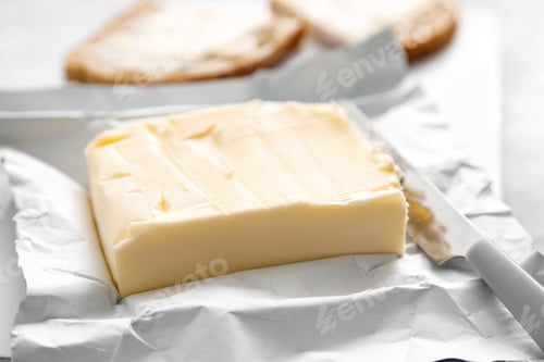 Preview: Block of butter with butter knife in a open pack. Buttering bread