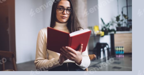 Preview: Positive woman enjoying book in cafeteria