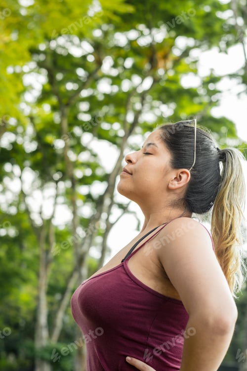 Preview: vertical close-up of a beautiful latin girl, ecologist nourishing her lungs with fresh air