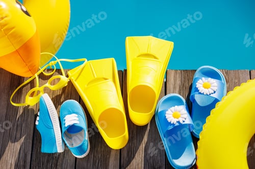 Preview: Beach flip-flops and sunglasses on wooden planks near swimming pool