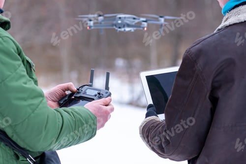 Preview: area planners survey the surroundings with a drone, hands with drone remote controller and a laptop
