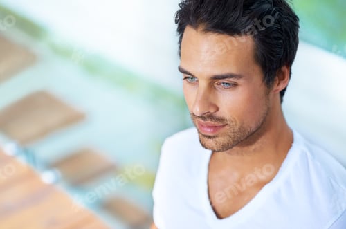 Preview: Hes clam and collected. A handsome young man sitting with his back agains a pane of glass.