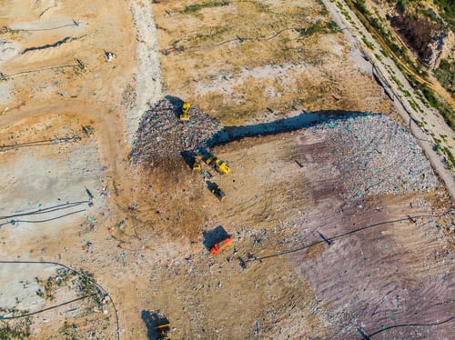 Preview: Aerial view from above of dumping site. Garbage trucks. Yellow tractor. Waste sorting. Landfill of