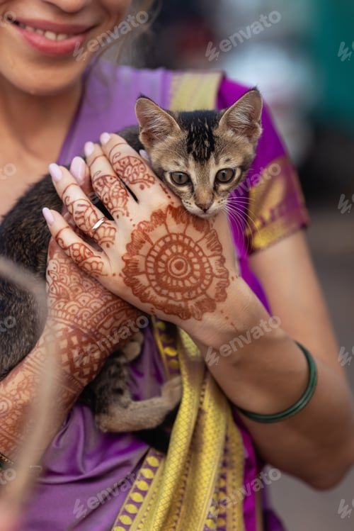 Preview: On her wedding day, the bride holds a kitten with mehndi-covered hands
