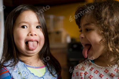 Preview: Two playful kids sticking their tongues out at each other