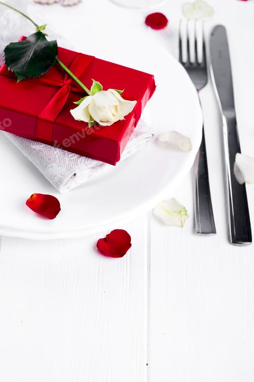 Preview: Elegant holiday table setting with red ribbon gift