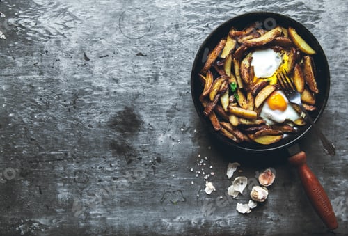 Preview: Fried potatoes and eggs in a pan close-up. horizontal