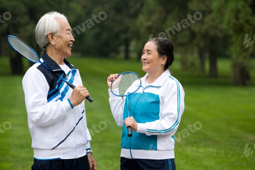 Preview: Senior Couple Holding Badminton Rackets in a Park