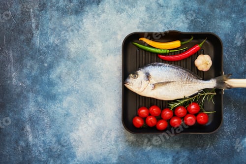 Preview: Raw sea bream fish with vegetables in pan on blue background. Top view, copy space.