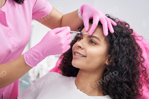 Preview: Cosmetologist performs procedure for eliminating frown lines on patient face
